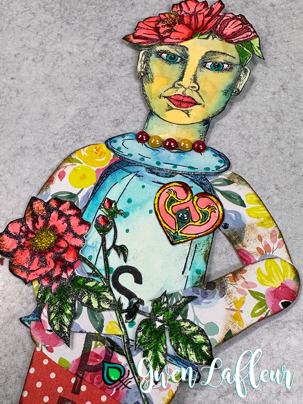 Closeup of a stamped and watercolored art doll made with stamps by Gwen Lafleur, patterned paper, and watercolors.